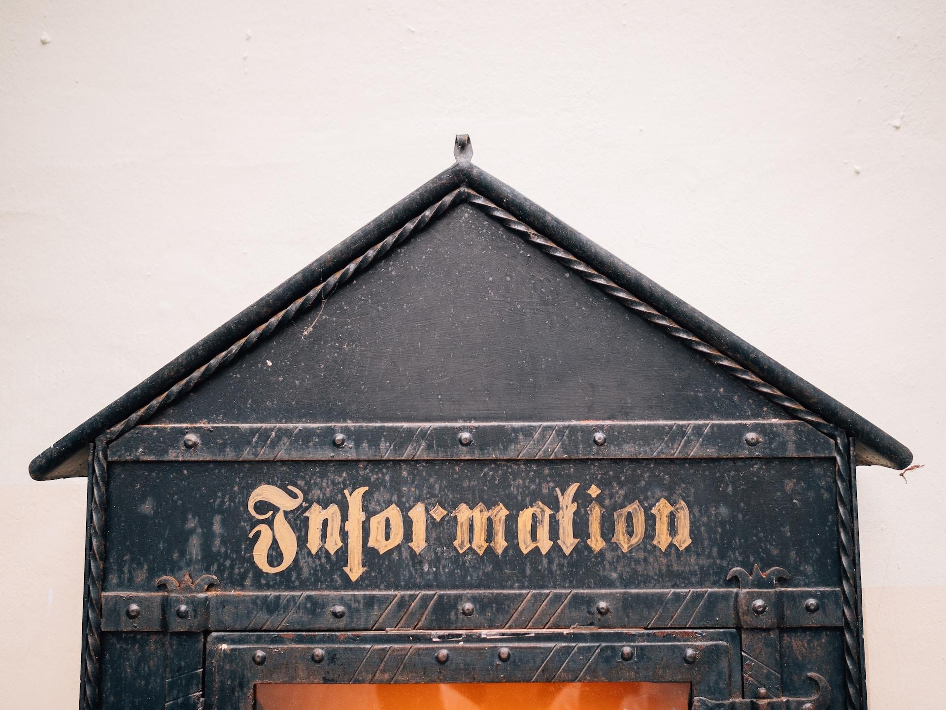 Auf einem hausförmigen Kasten steht in alter Schrift 
