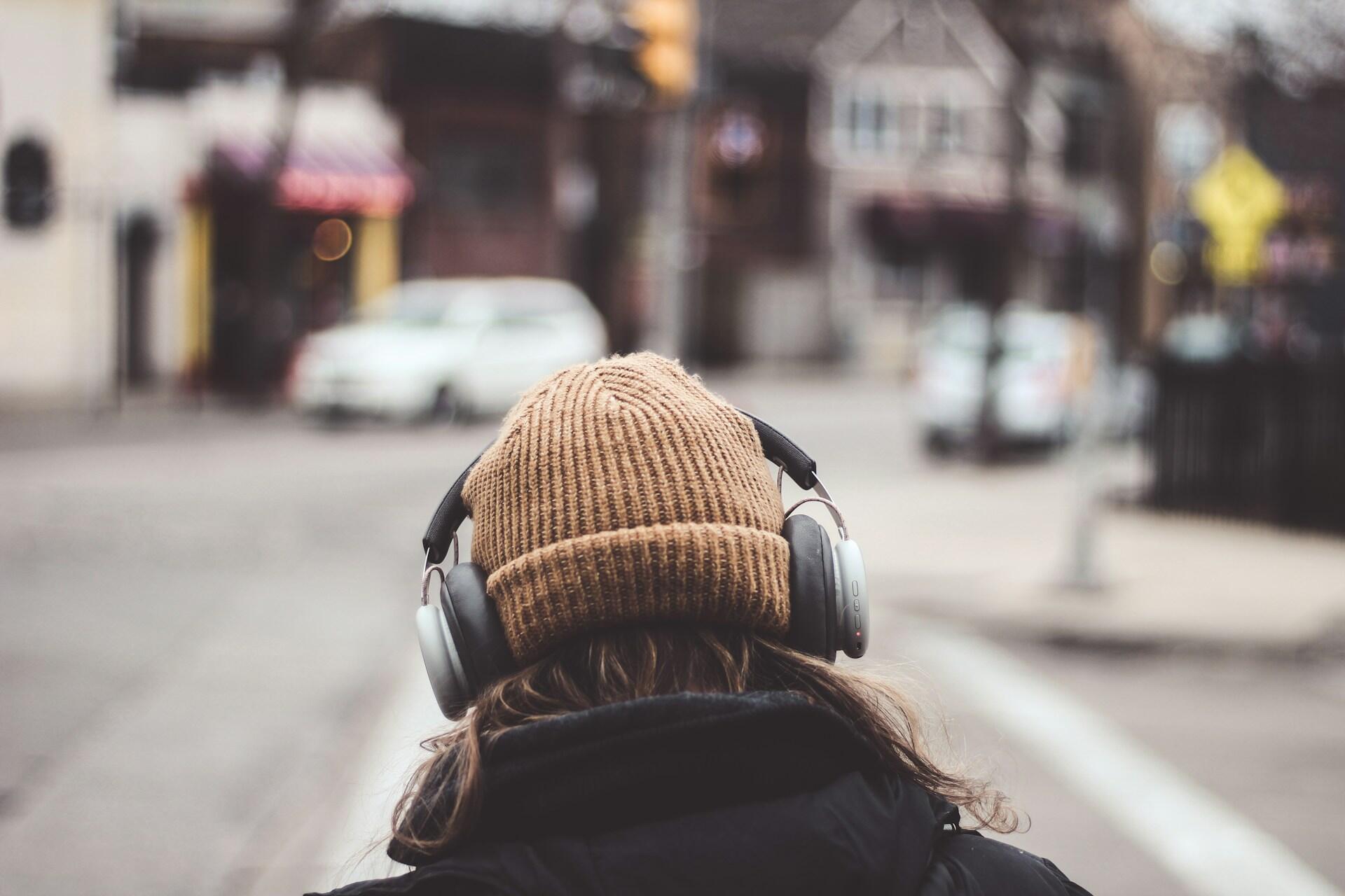 Frau hört einen Französisch Podcast über Kopfhörer