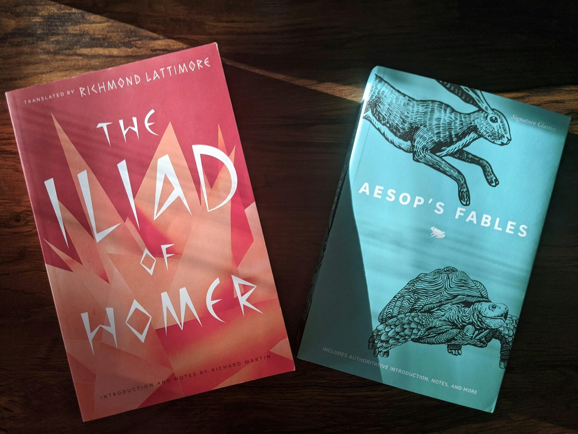 Zwei Bücher liegen auf Holztisch.