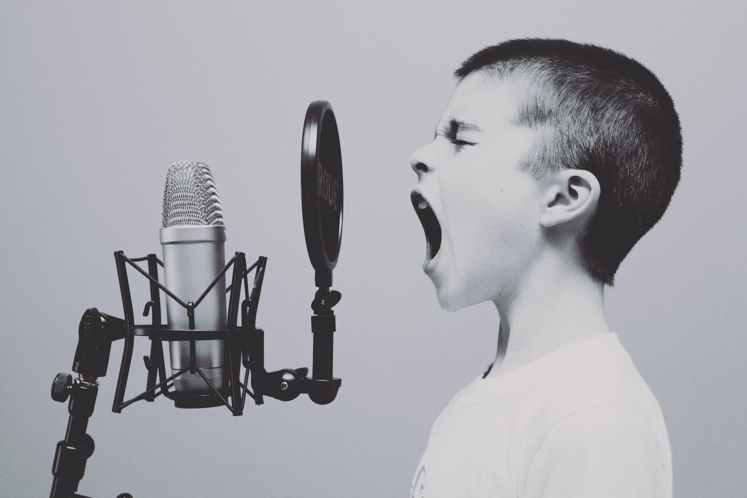 Junge singt vor Mikrofon
