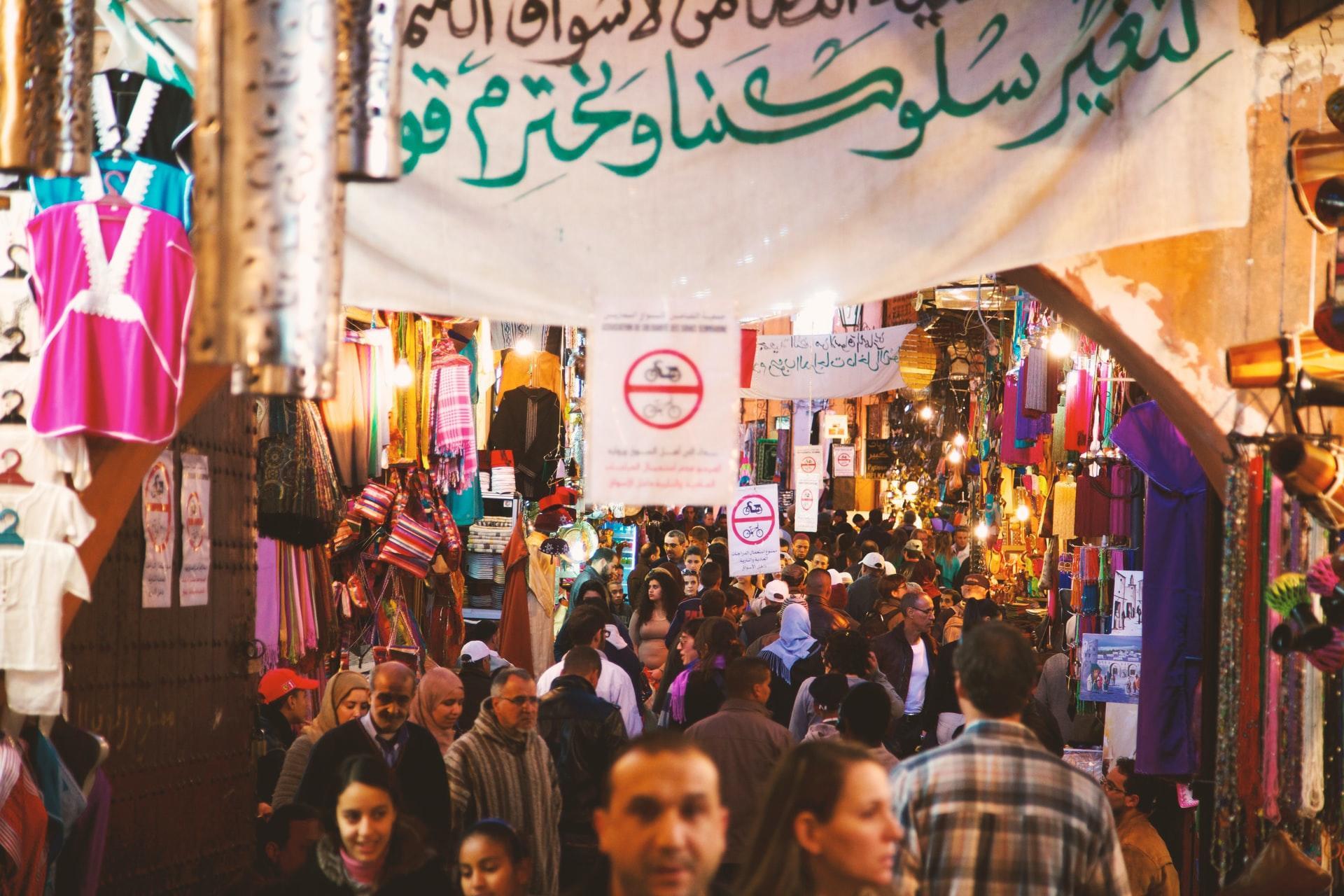 Markt mit vielen Menschen und arabischen Schriftzeichen.