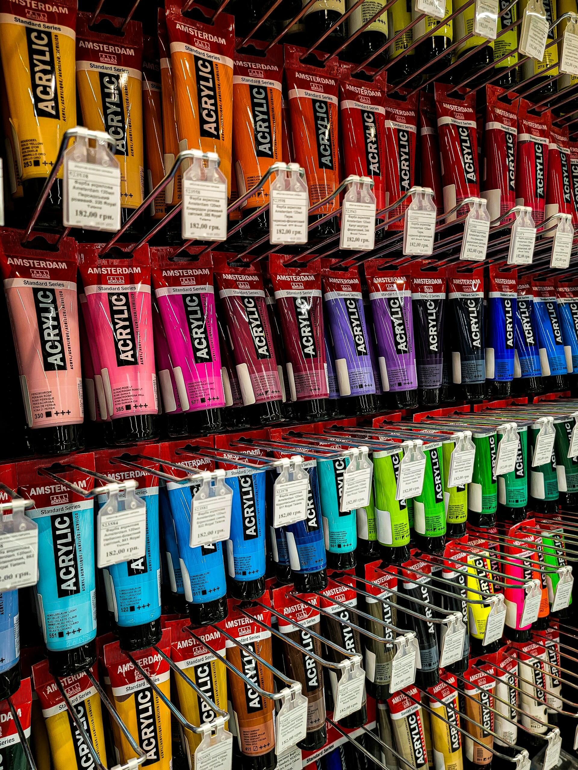 Mehrere Acrylfarben an einer Wand aufgehangen.