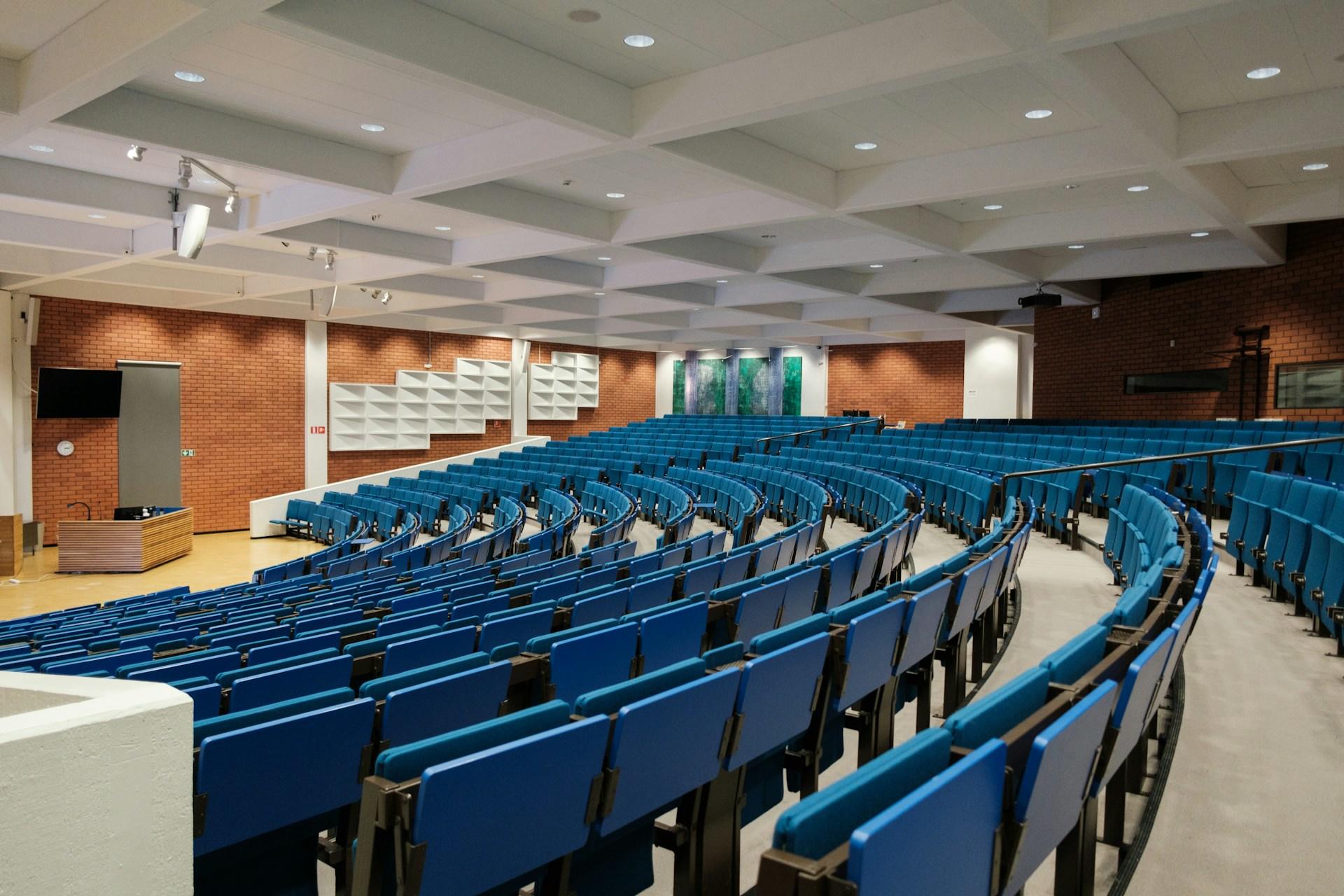 Ein großer Hörsaal mit blauen Stühlen
