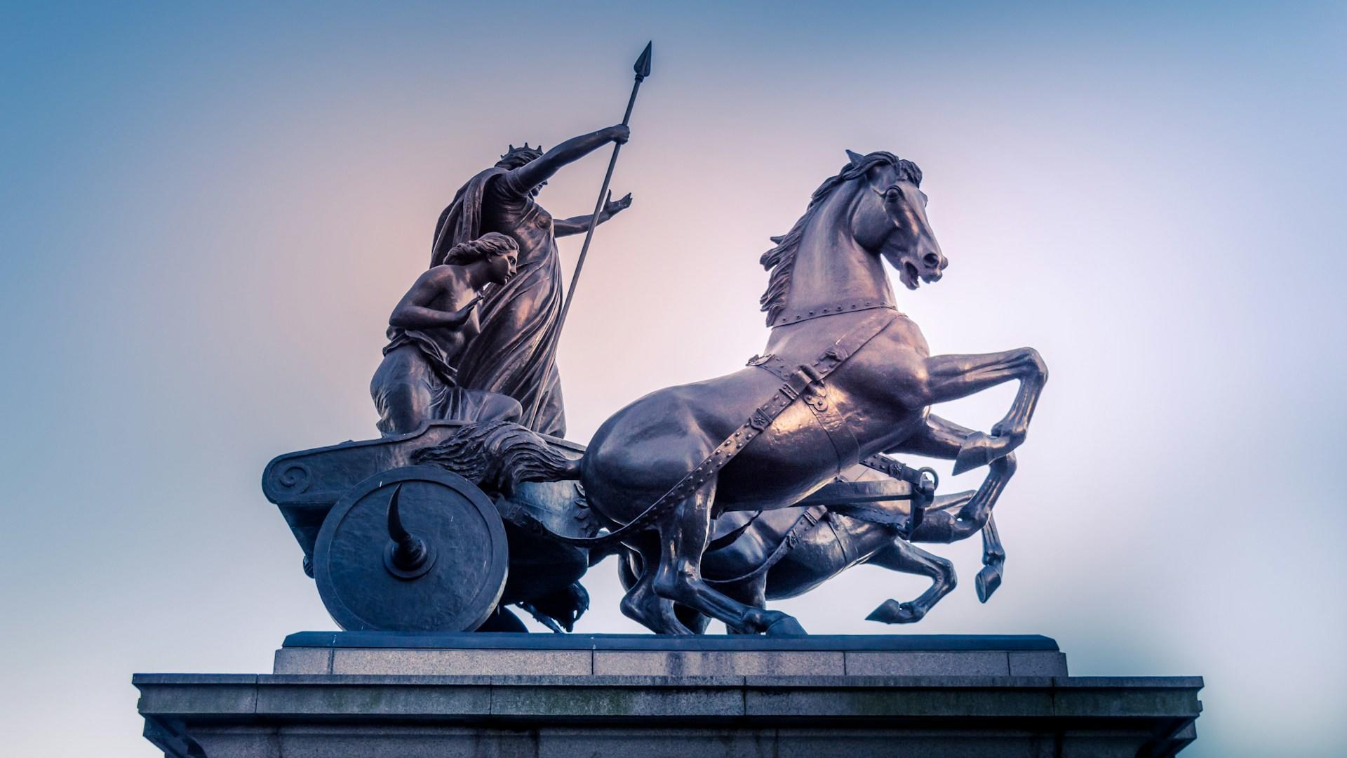 Eine Statue von einem Wagen mit zwei Pferden und zwei Personen