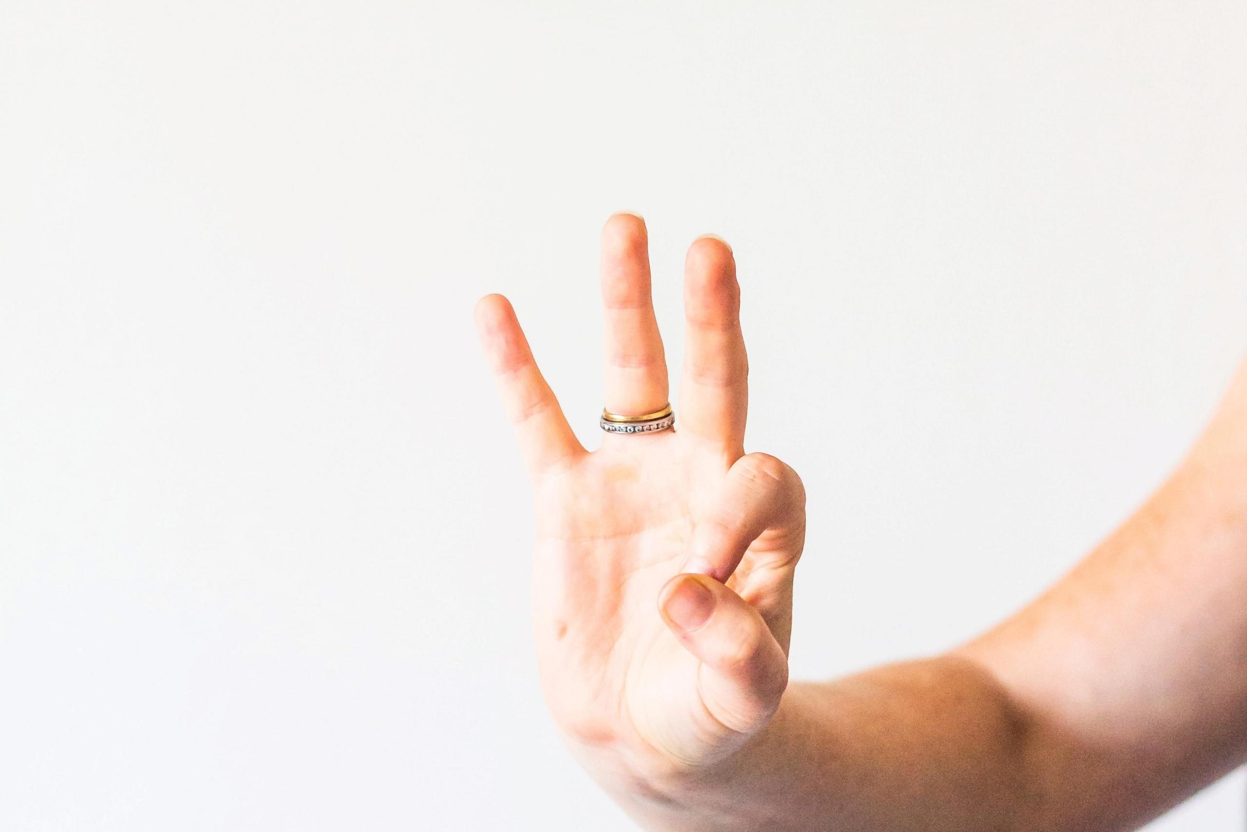 Hand zeigt drei Finger.