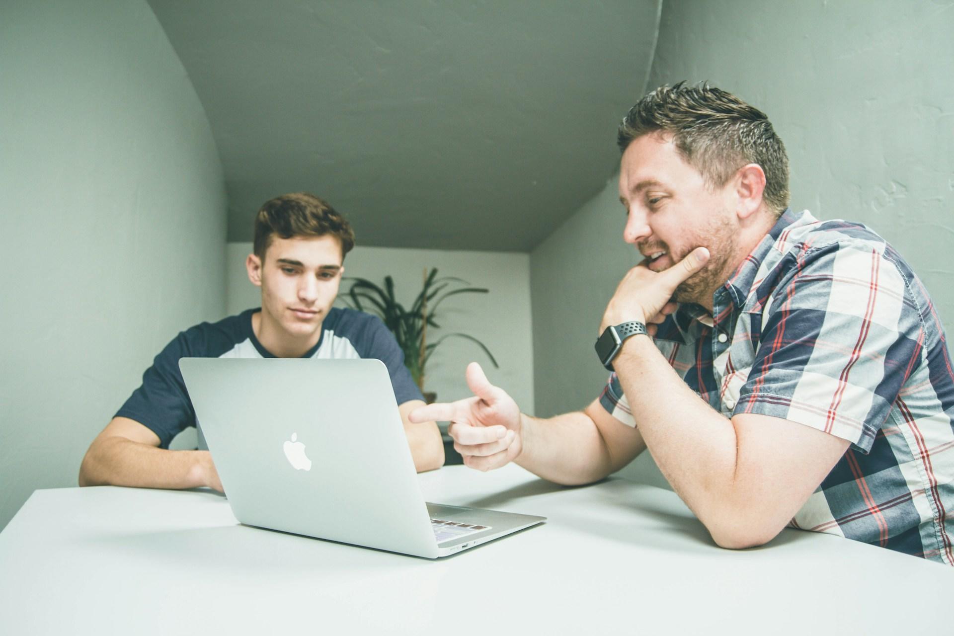 Junge bei der Nachhilfe mit seinem Lehrer am Tisch