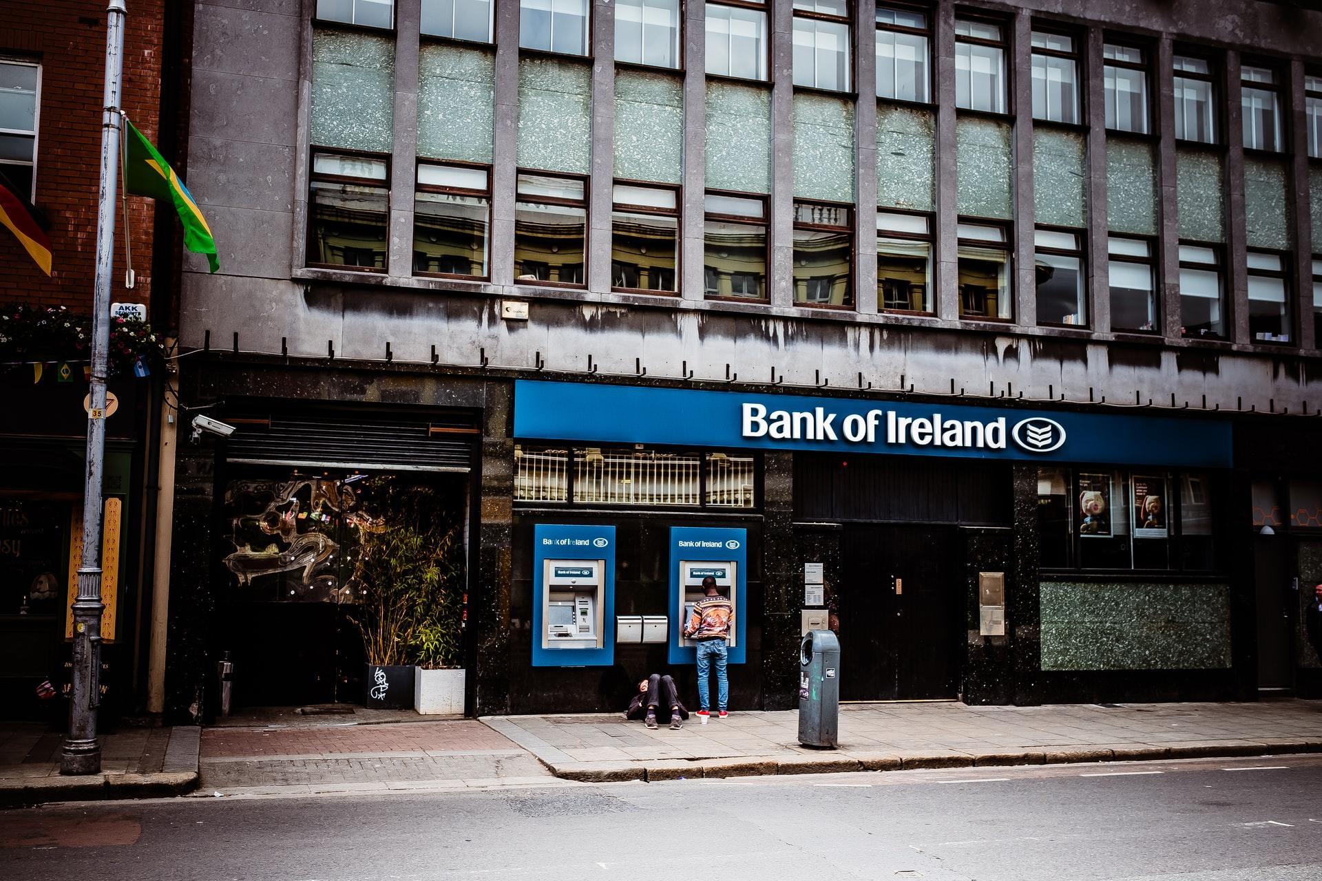 Gebäude mit Bankautomaten im Erdgeschoss vor Straße.