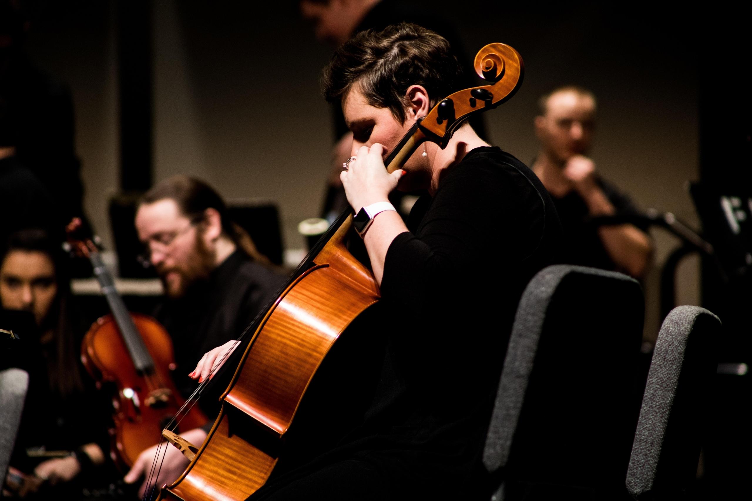 Das Cello wird zwischen de Beinen des Musikers auf einen Stachel gestellt.