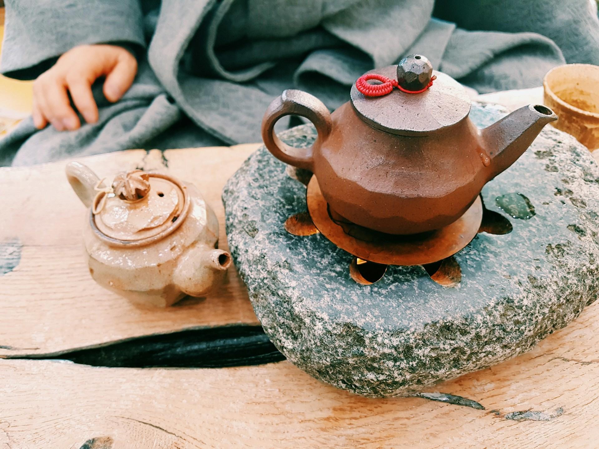 Teekanne aus braunem Ton auf erhitztem Stein