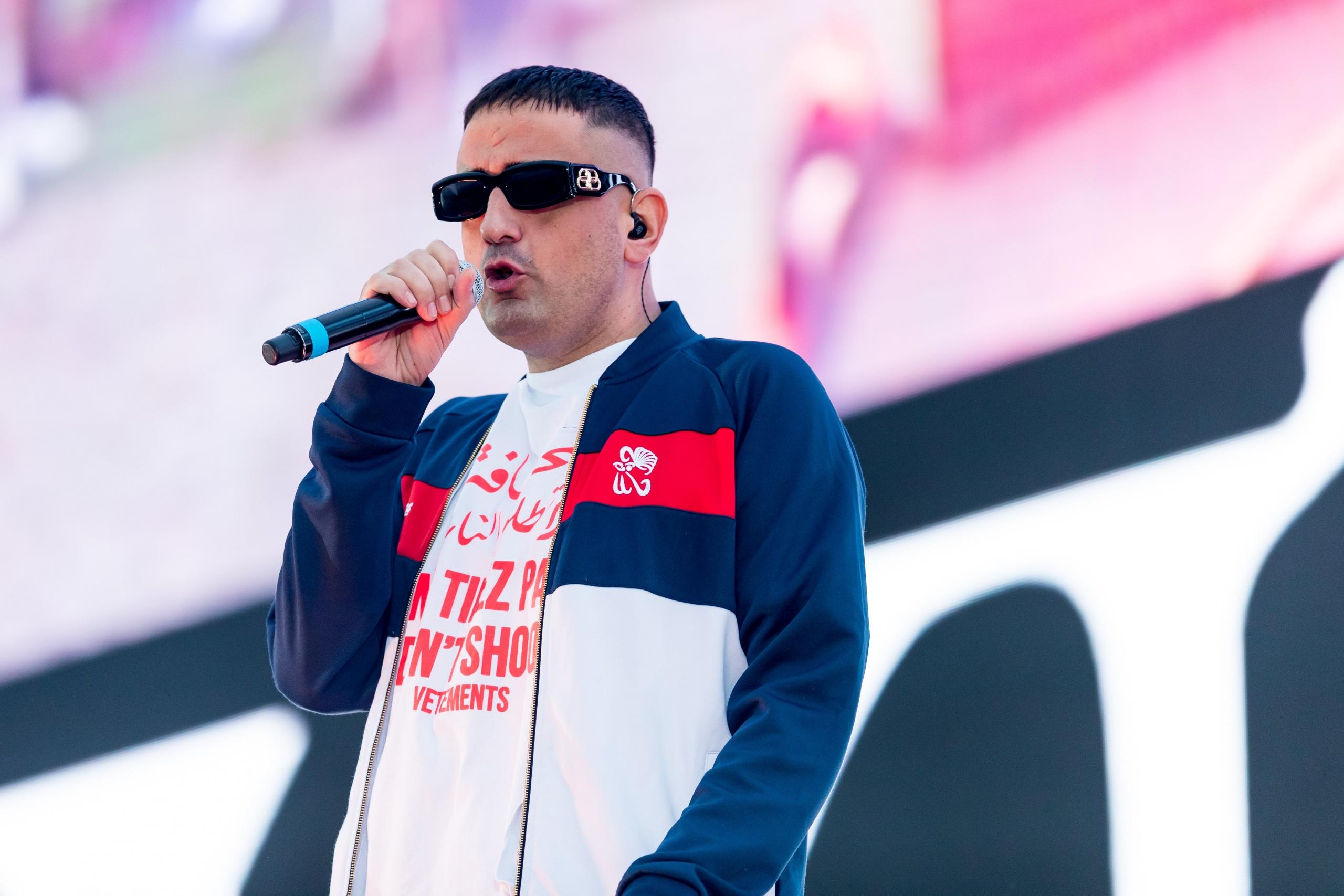 Der Deutschrapper Haftbefehl steht mit Sonnenbrille und Mikrofon auf der Bühne und rappt.