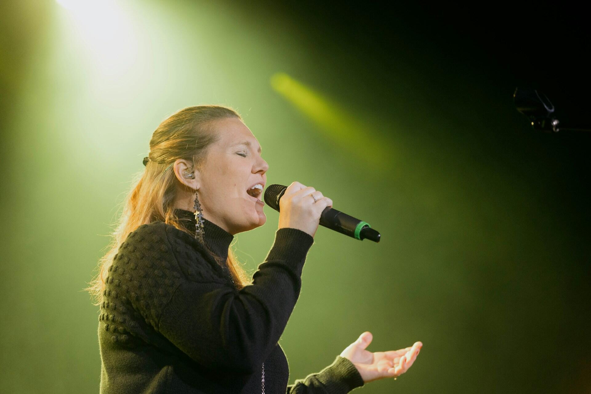 Frau singt mit Mikro in der Hand.