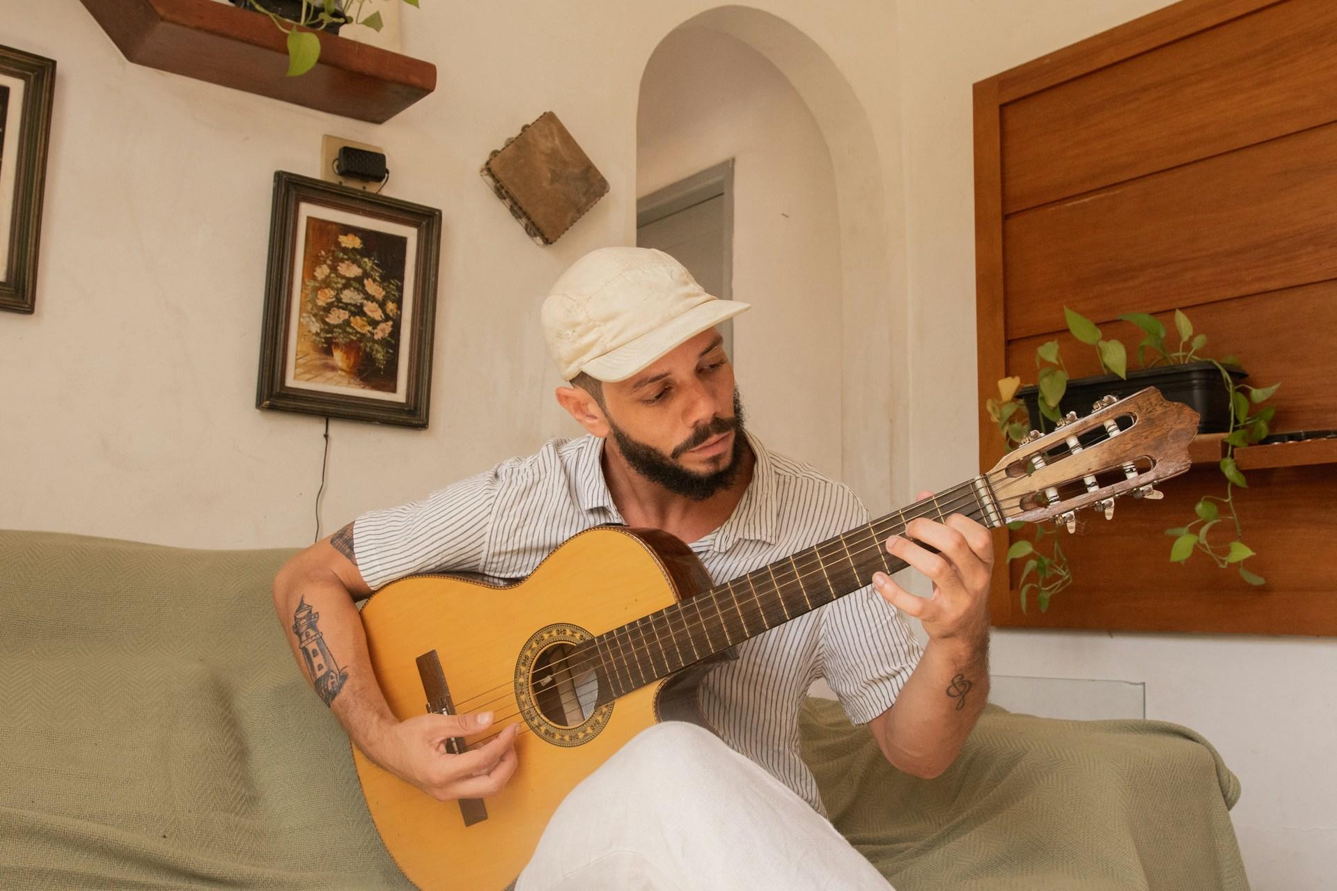 eine Person sitzt auf dem Sofa und spielt Gitarre