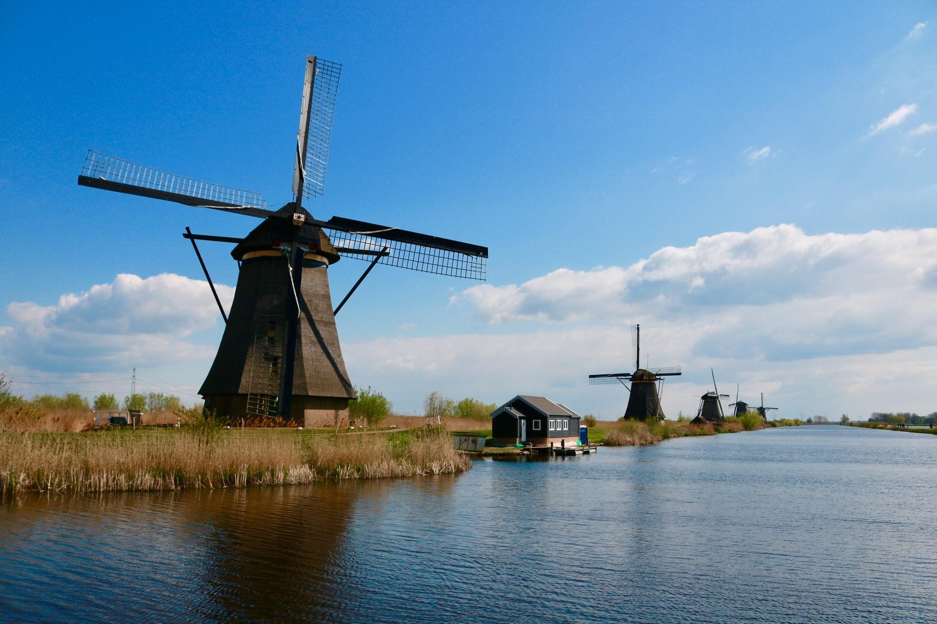 Windmühlen am Ufer eines Flusses.