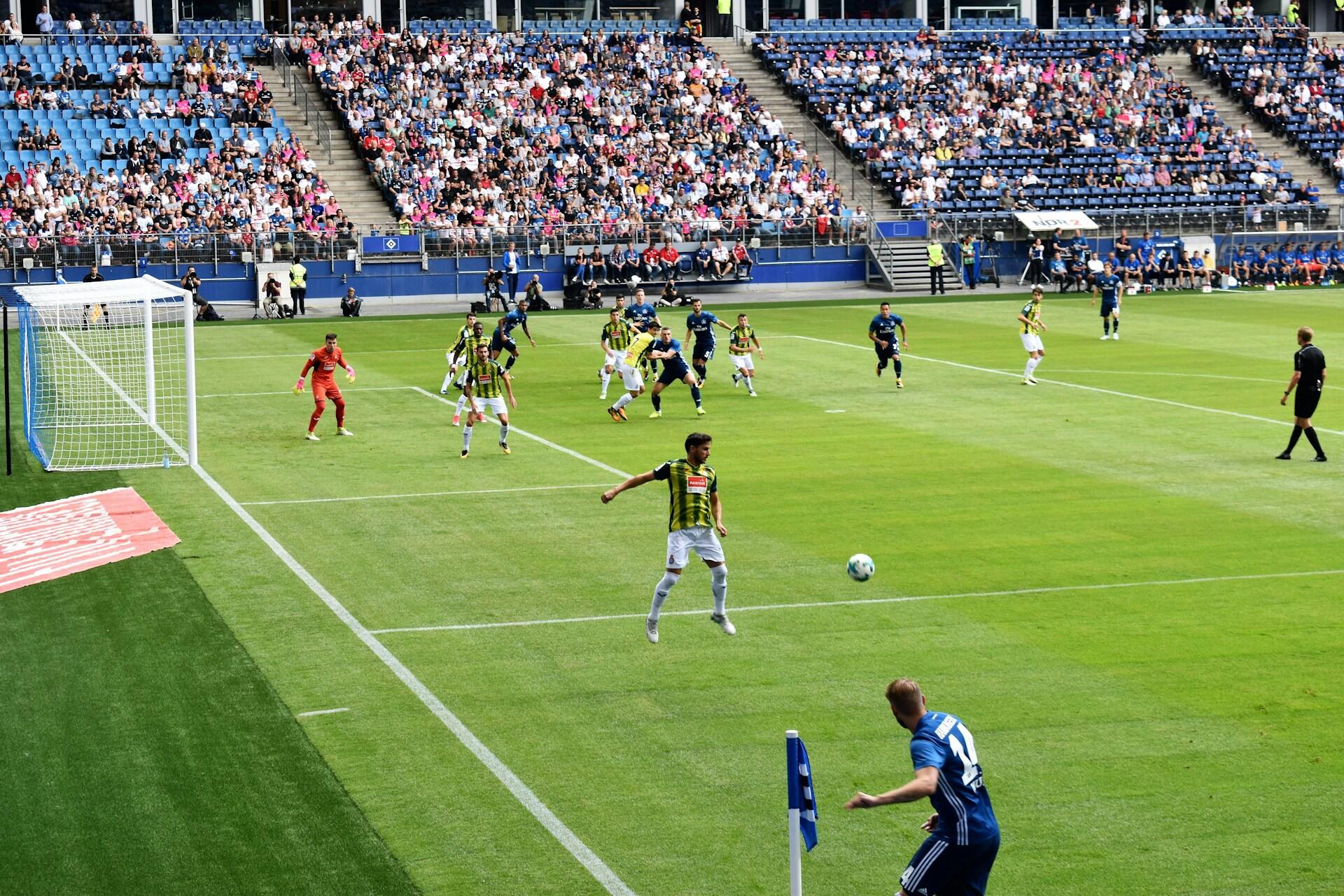 Männer spielen Fußball in Stadion.