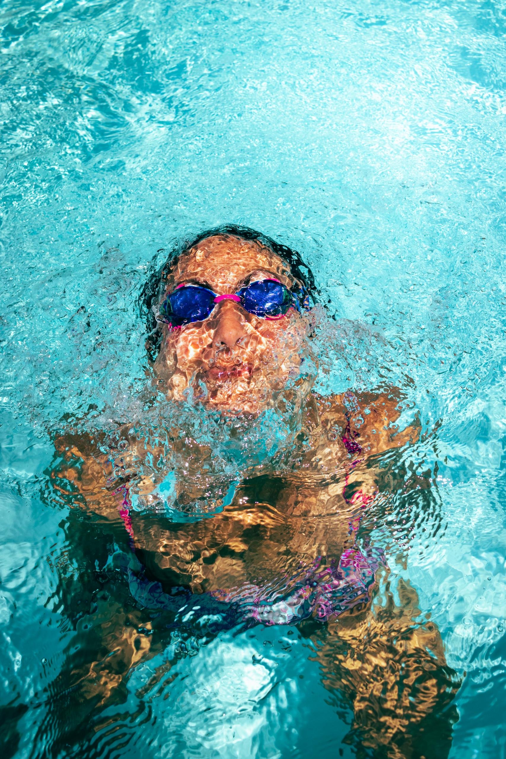 Eine Person mit Schwimmbrille unter Wasser
