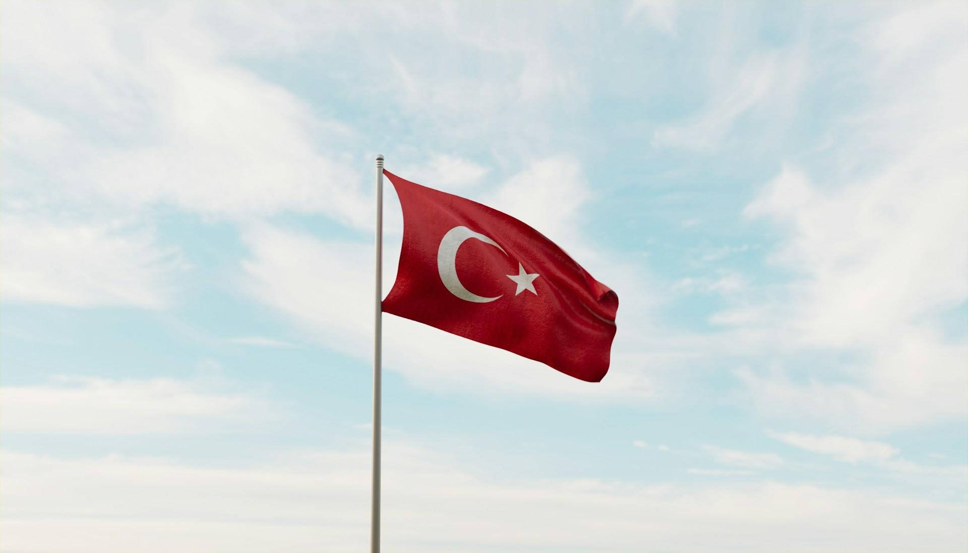 Die türkische Flagge weht vor leicht bewölktem Himmel