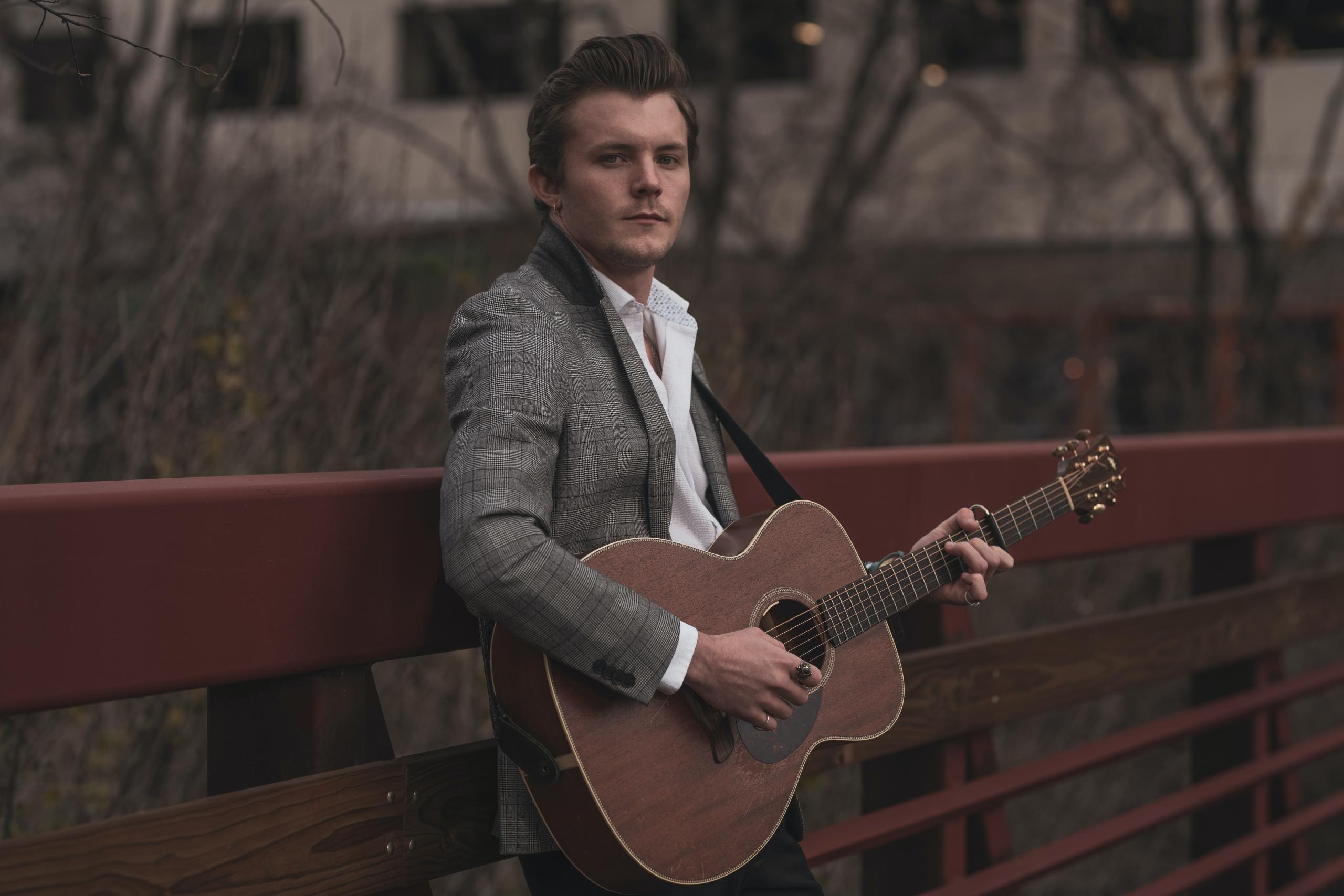 Dieser Mann spielt eine Westerngitarre. Welche Art der Akustikgitarre passt wohl am besten zu dir?