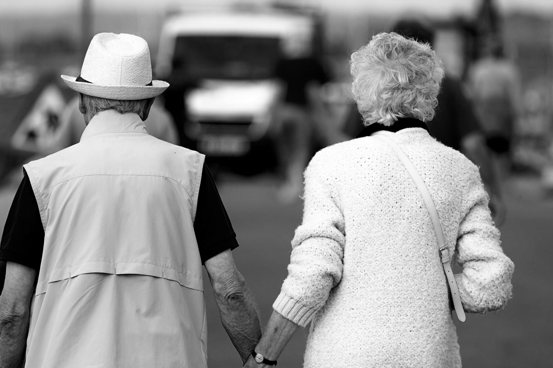 Ein altes Ehepaar läuft Händchen haltend die Straße entlang und hat durch Paarcoaching eine lange, erfüllte Ehe genossen