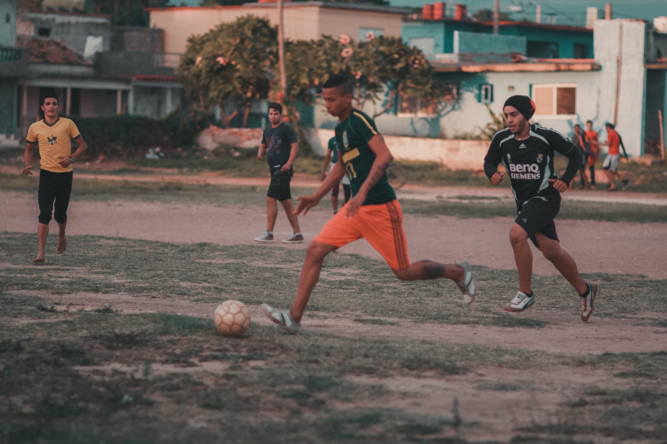 Ein junger Fußballer dribbelt den Gegnern davon. Solche Leistungen sind nur mit dem richtigen Fußballausdauertraining.