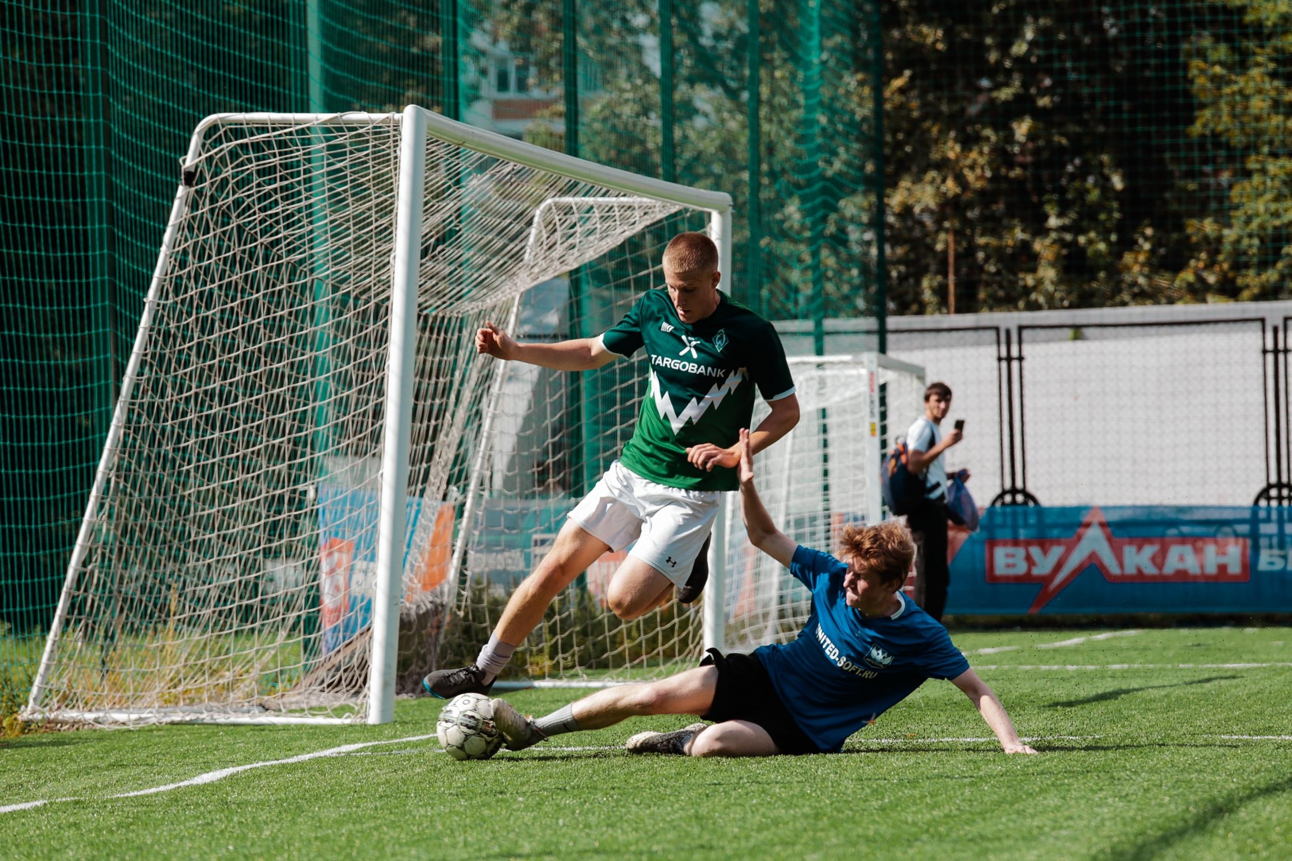 Ein Fußballspieler grätscht seinem Gegner den Ball weg. Wer so einen Einsatz mit einer guten Defensivtaktik verbindet, hat gute Chancen, kein Tor zu kassieren.