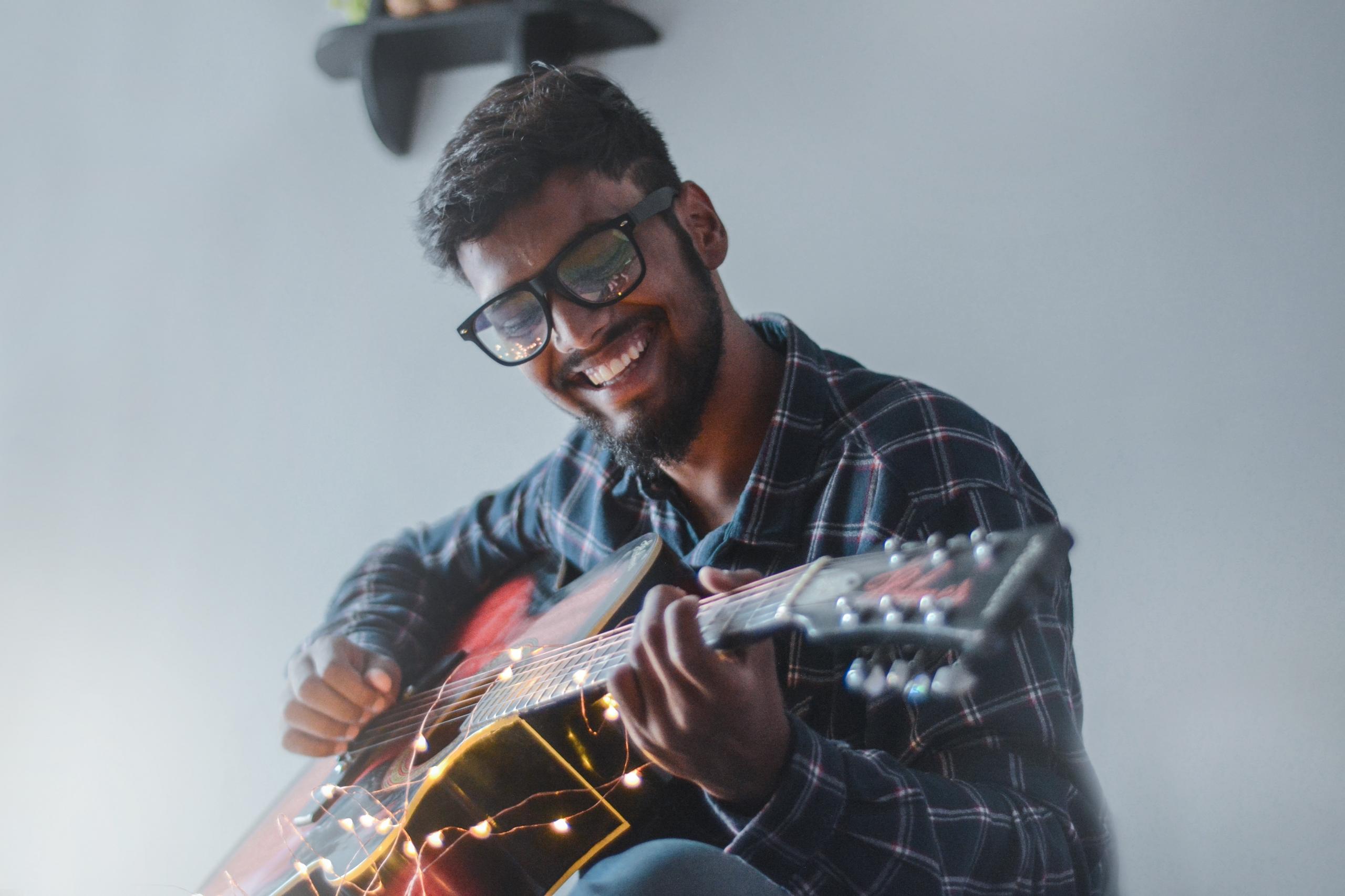 Das glückliche Gesicht dieses Gitarristen zeigt uns, wie viel Spaß Gitarre lernen machen kann.