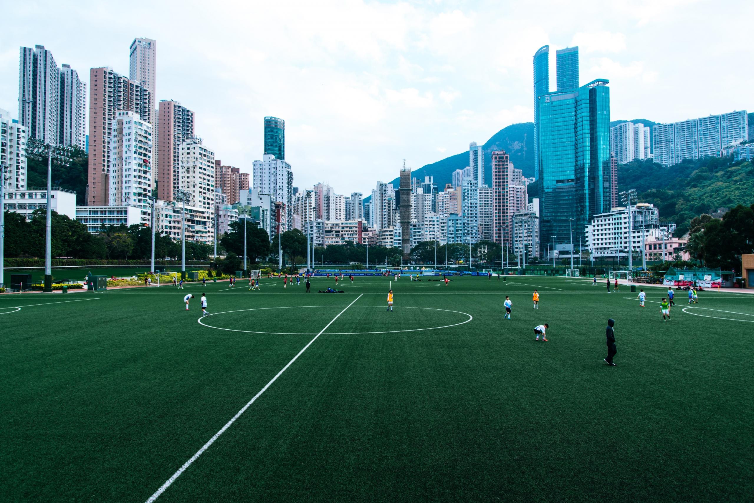 Ein großer Fußballplatz eines Jugendvereins inmitten von Hochhäusern. Egal ob auch solch modernen Plätzen oder auf dem Bolzplatz nebenan - Fußballspielerinnen und Fußballspieler sollten auf ihre Ausdauer achten.