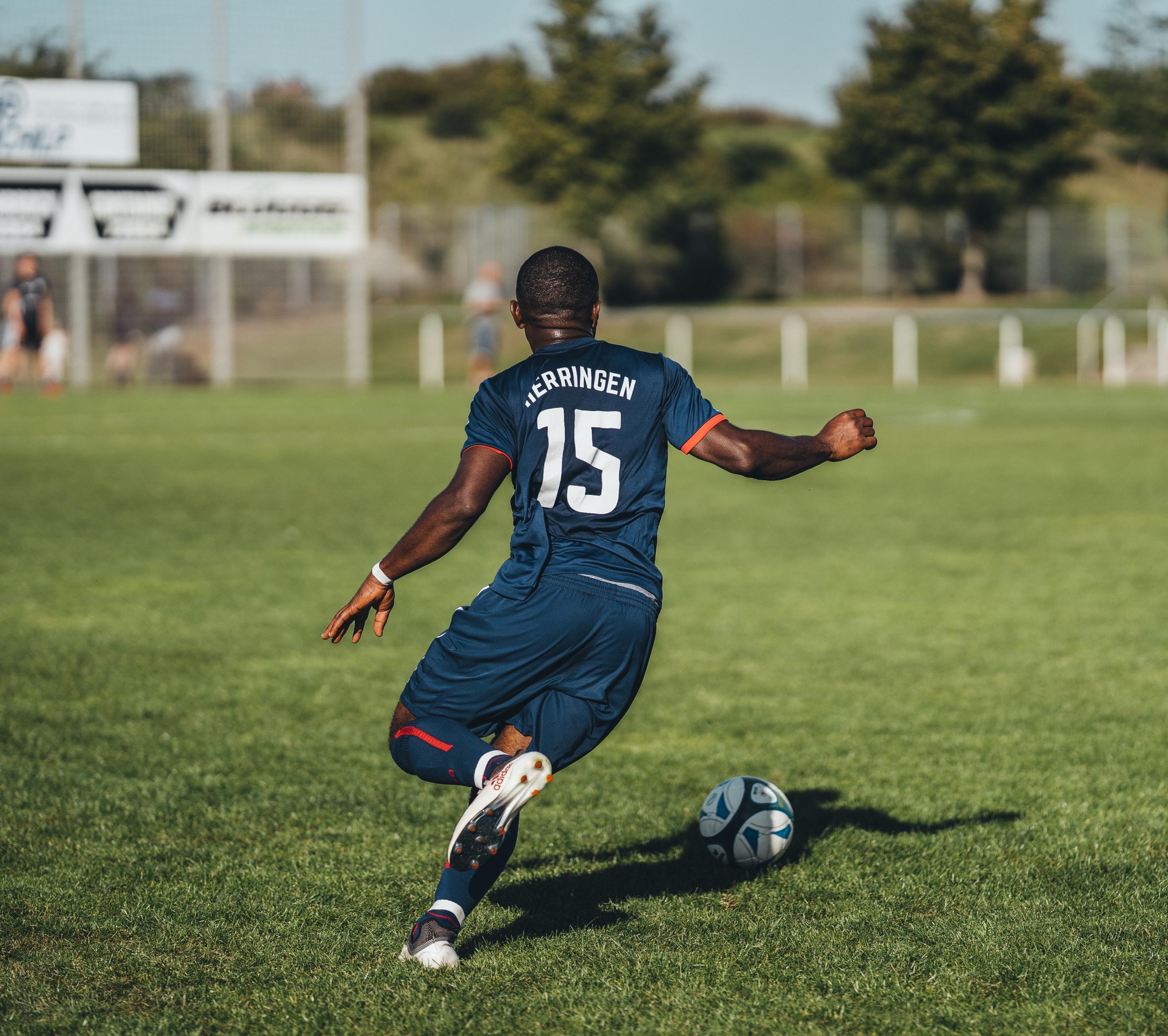 Ein Fußballspieler dribbelt den Ball. Technische Fähigkeiten sind für den Spielaufbau sehr hilfreich.
