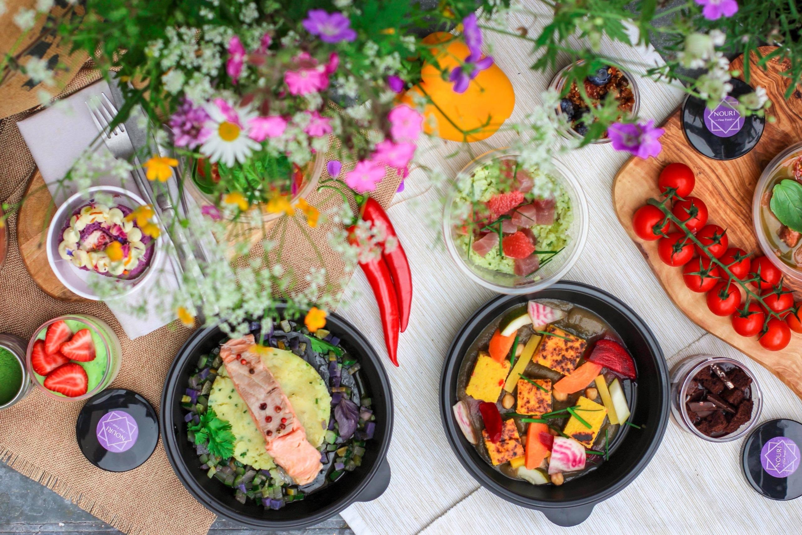 Glutenfreies Gemüse, andere bunte Zutaten und ein Blumenstrauss auf einem Tisch. Eine glutenfreie Ernaehrung muss nicht langweilig sein.