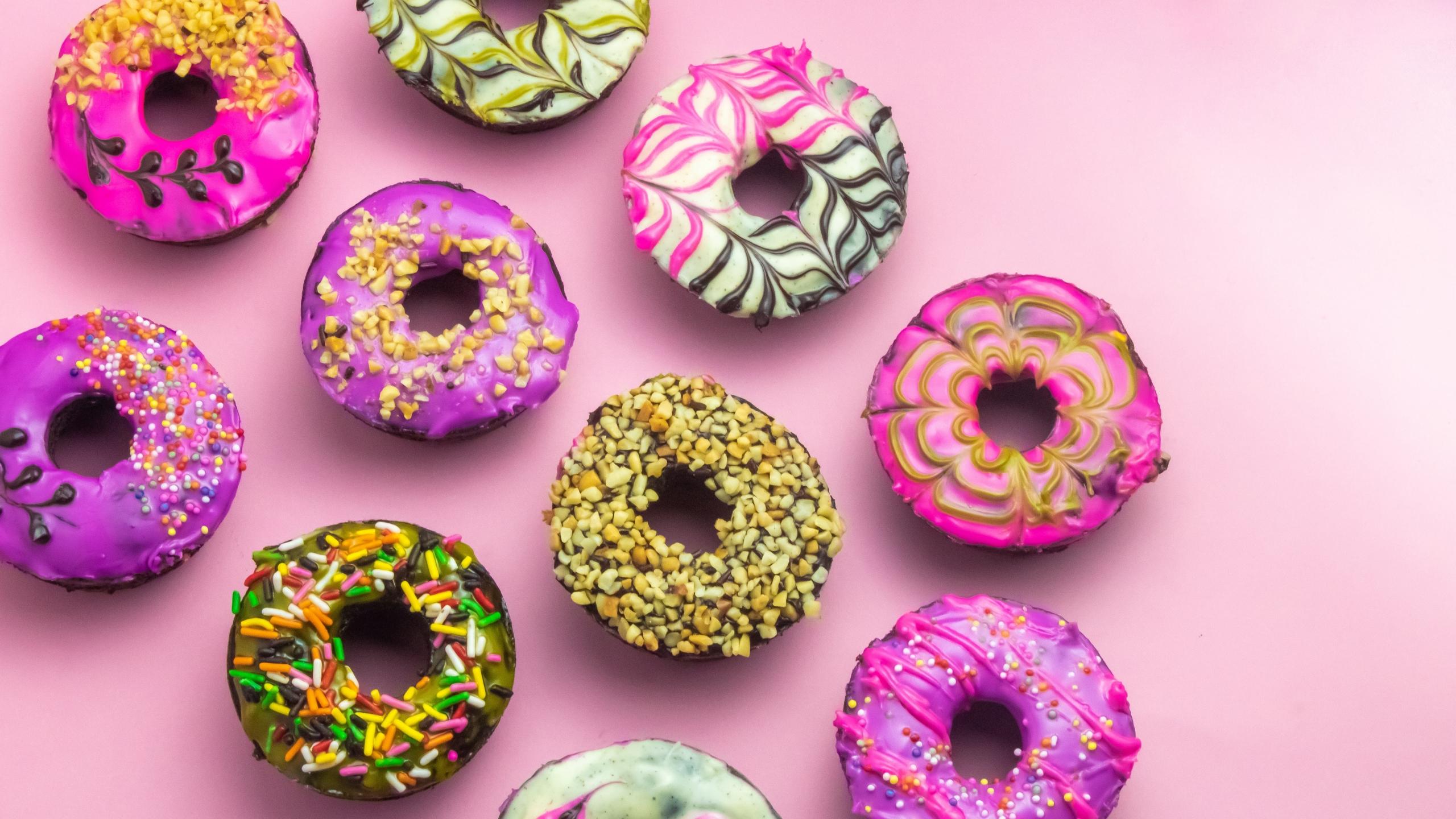 Glutenhaltige bunte Donuts auf rosa Grund