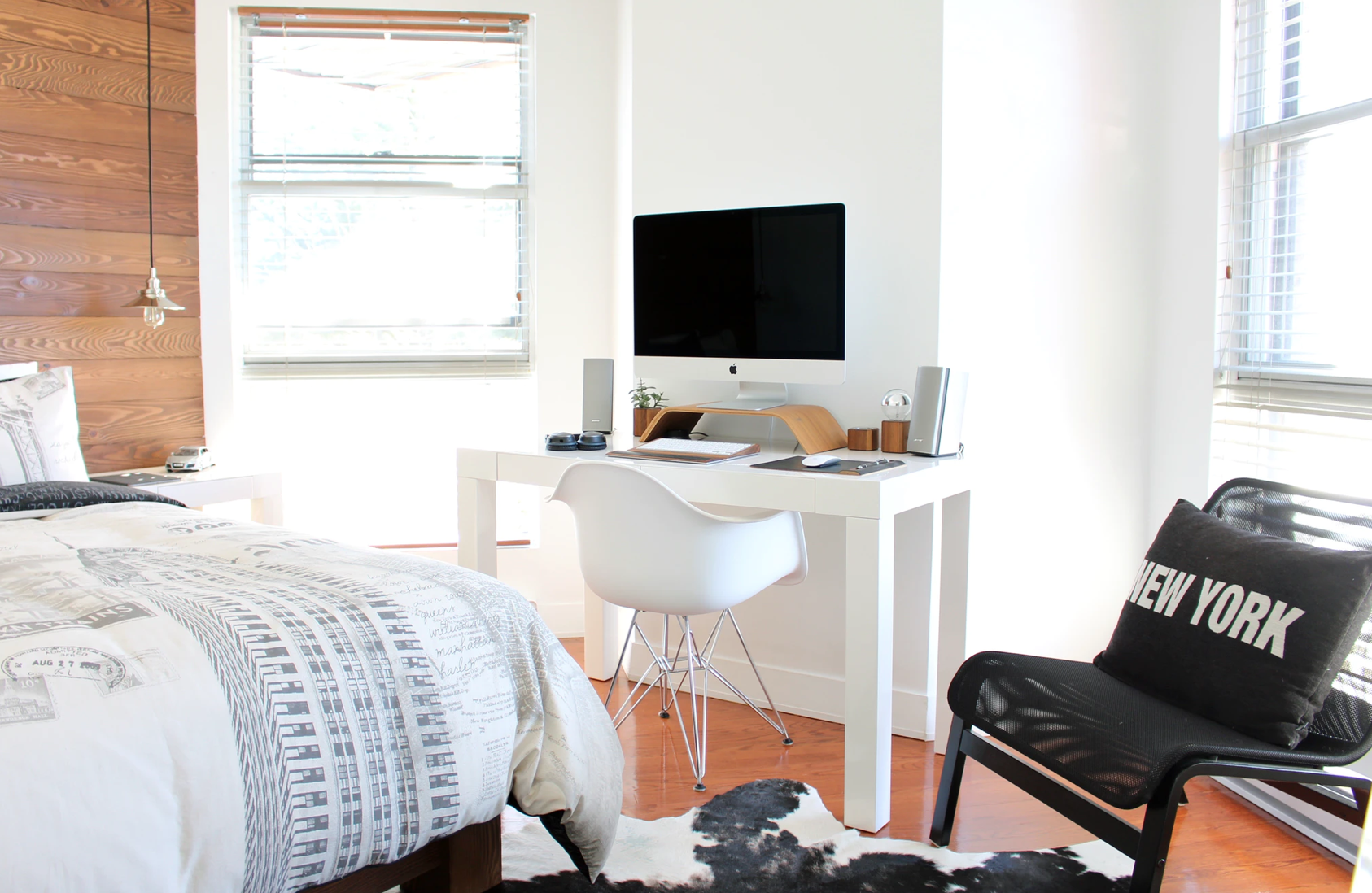 Ein helles Schlafzimmer, zwischen Bett und Stuhl steht ein Schreibtisch mit Bildschirm und Tastatur darauf. Ein geeigneter Platz, um Hausaufgaben zu machen!