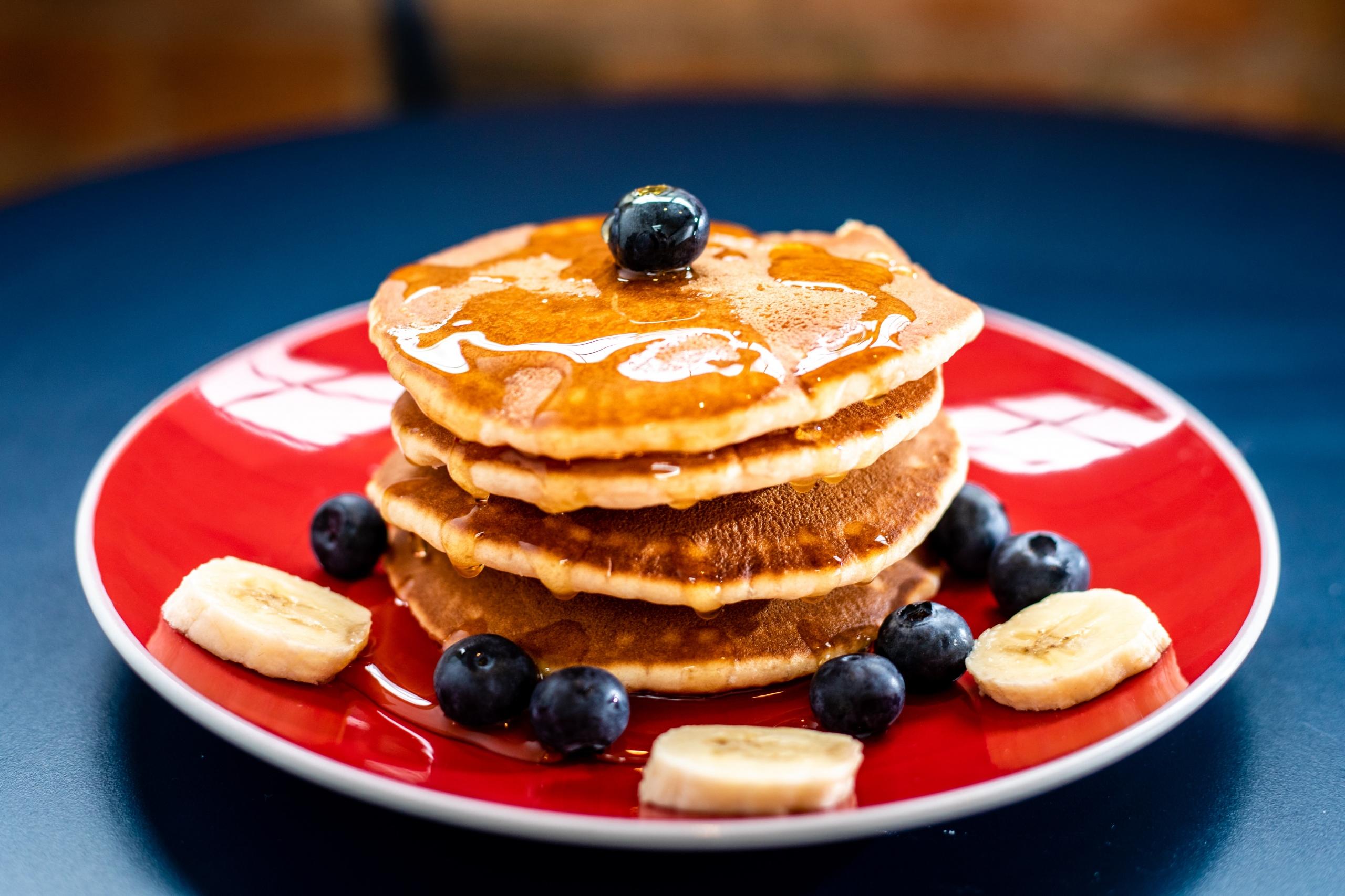Stapel Pfannkuchen auf rotem Teller. Mit dem richtigen Mehl lassen sich viele Teige glutenfrei zubereiten.