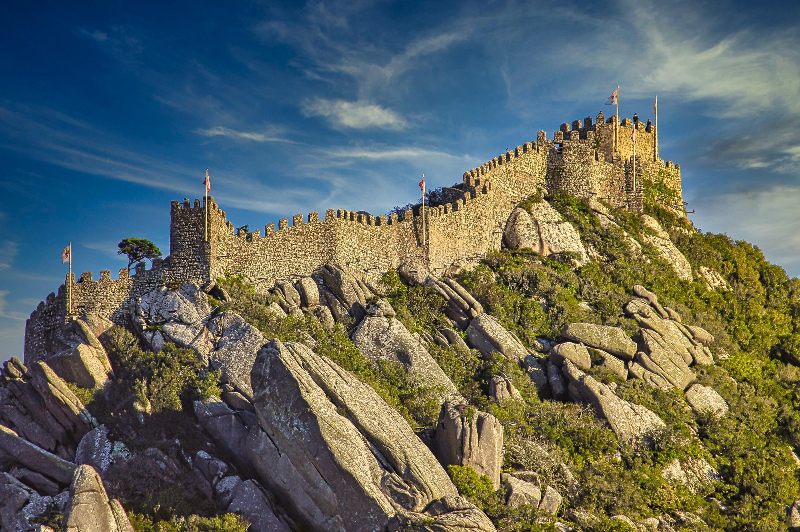 Die maurische Burg in Sintra thront auf einem Berg und lockt Reisende in Portugal zu sich.
