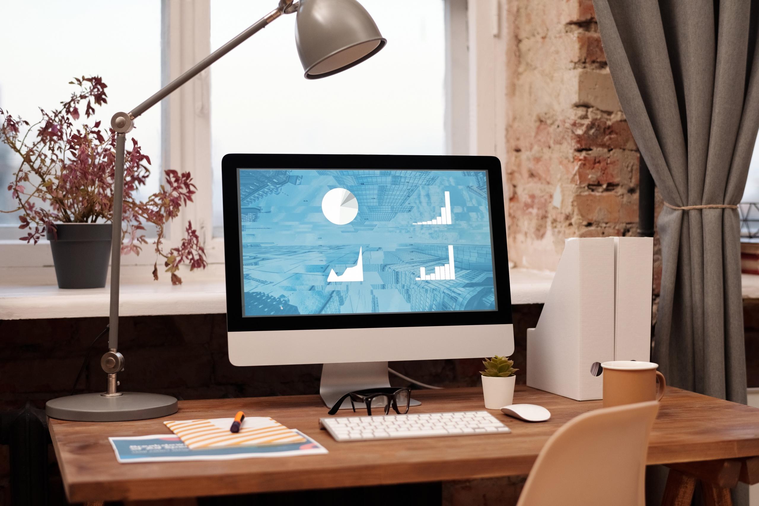 Ein Mac Computer steht auf einem Tisch und zeigt einer Präsentation. Willst auch du PowerPoint lernen?