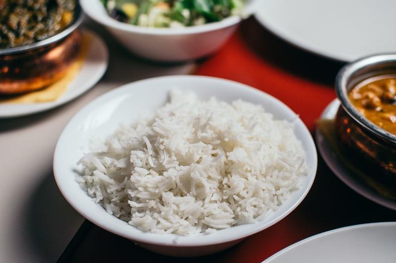 Ein Tisch mit mehreren Schalen mit koreanischen Gerichten, mittig eine Schüssel Reis.