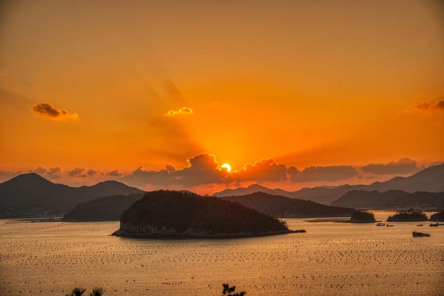 Ein roter Sonnenuntergang über dem Meer, im Meer verschiedene kleine Inseln.