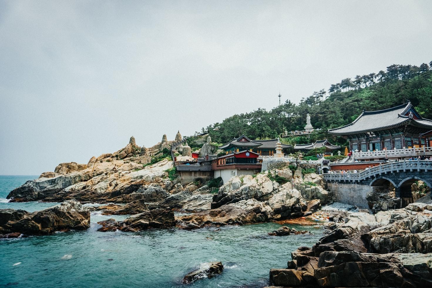 Blick auf den Yonggungsa-Tempel in Südkorea,nahe Busan, im Vordergrund das Meer.