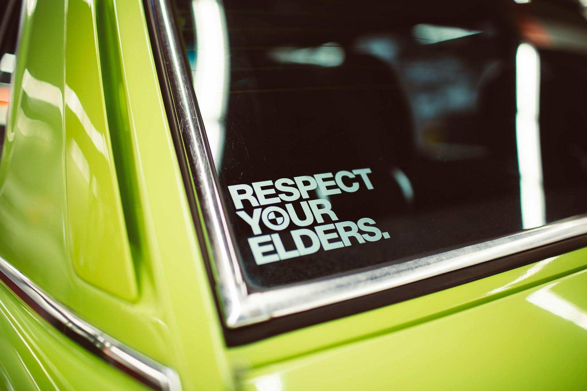 Respect your elders steht auf einem Aufkleber auf der Rückscheibe eines Autos. Im Koreanischen gibt es spezielle Höflichkeitsformen für Ältere.
