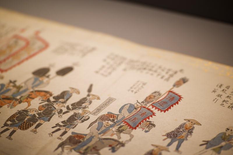 Eine Tuschezeichnung mit Reitern und Pferden sowie koreanischen Schriftzeichen.