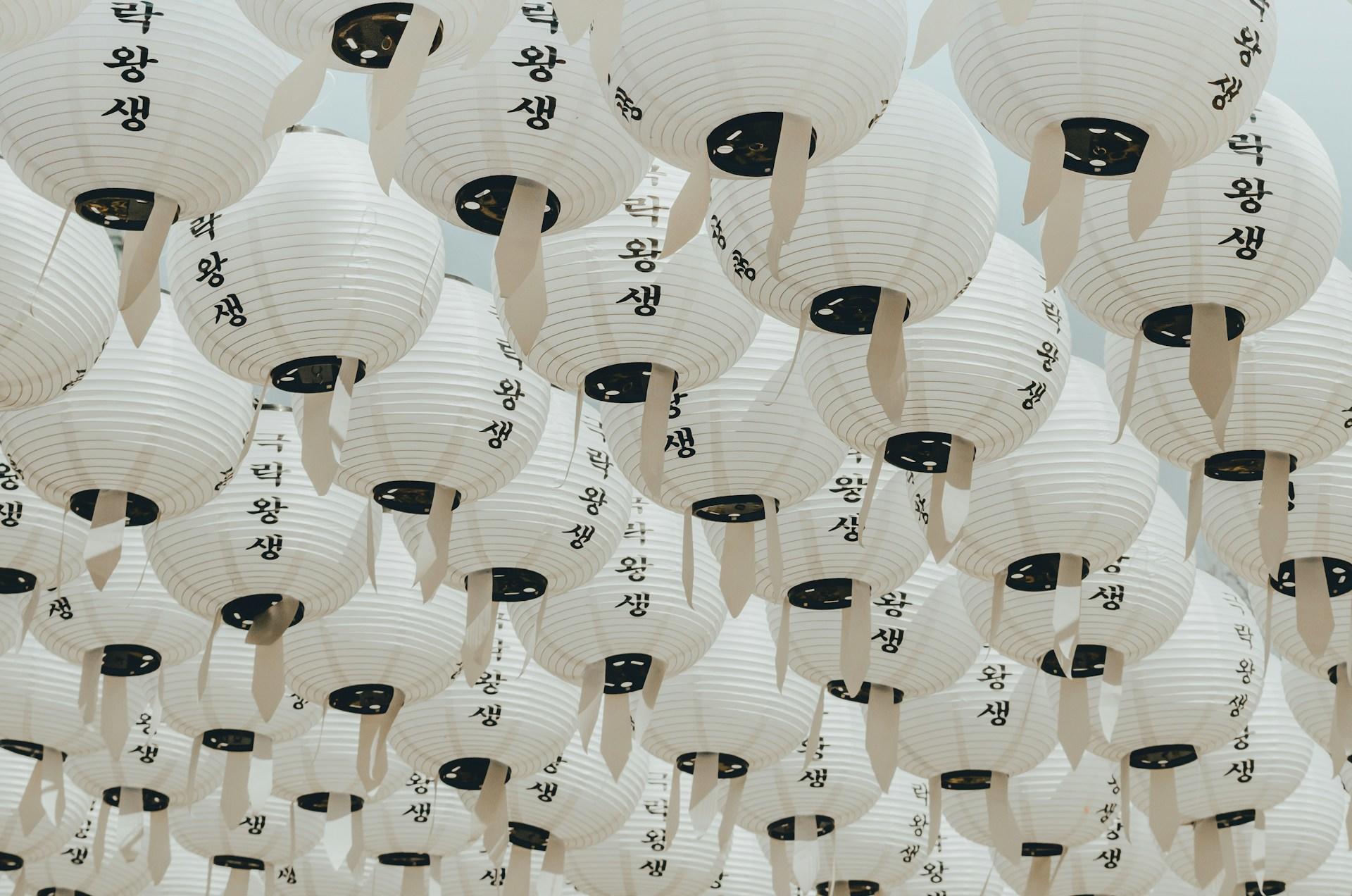 Weiße Lampions mit schwarzes Schrift.