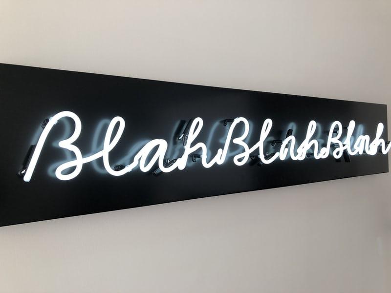 Auf einem schwarzen Schild steht in weisser Neon-Schrift "Blah, blah, blah".