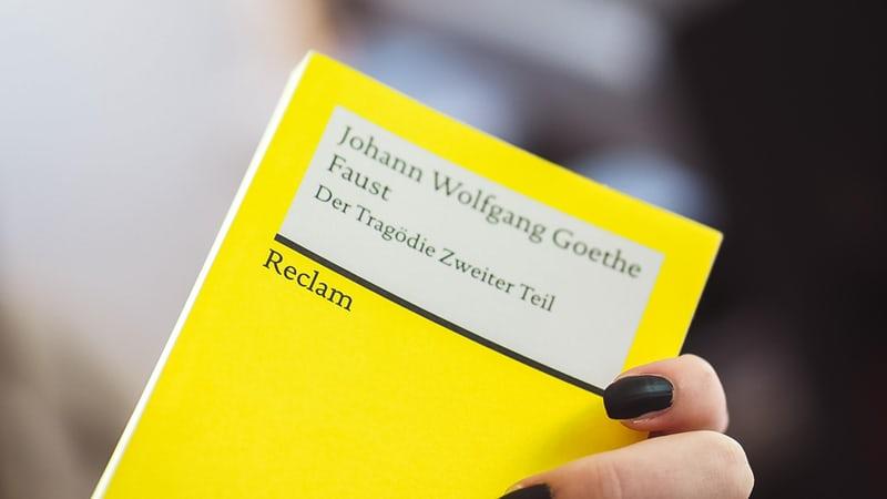 Eine weibliche Hand mit schwarz lackierten Fingernägeln hält ein gelbes Reclam-Heft in der Hand - Johann Wolfgang Goethe 