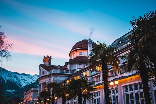 Ein altes Kurhotel mit Palmen an der Front und Schneebergen im Hintergrund findet man im Nordosten von Italien.