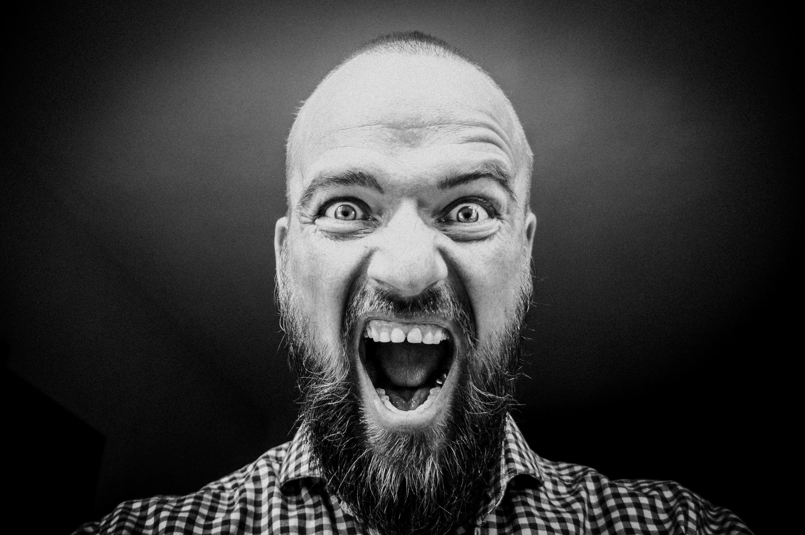 Ein Mann schaut mit weit geöffneten Augen und aufgerissenem Mund direkt in die Kamera.