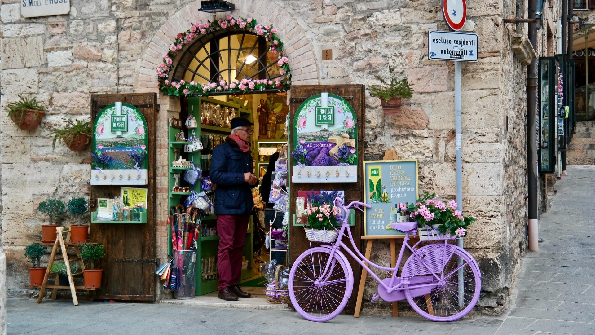 Ein mittelalterliches Geschäft mit einem lila Fahrrad davor wie es für die mittelitalienischen Regionen typisch ist!
