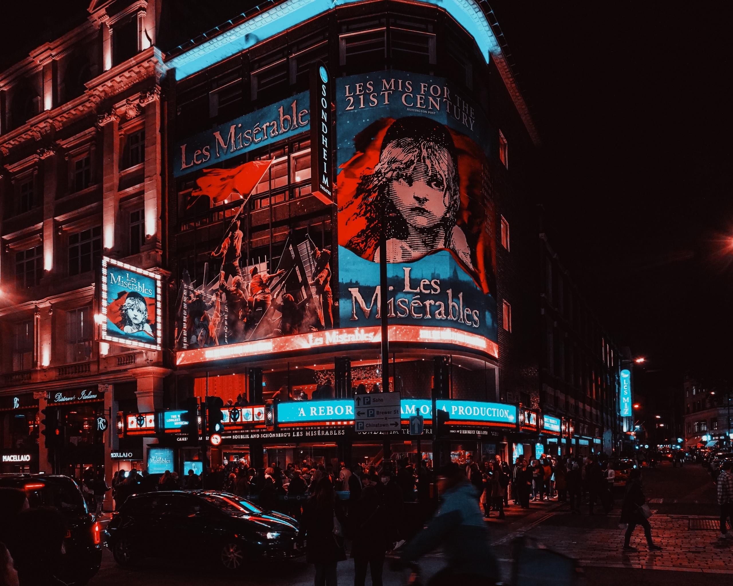 An einer Straßenecke in London wird mit Leuchtwerbung das Musical "Les Misérables" angekündigt.