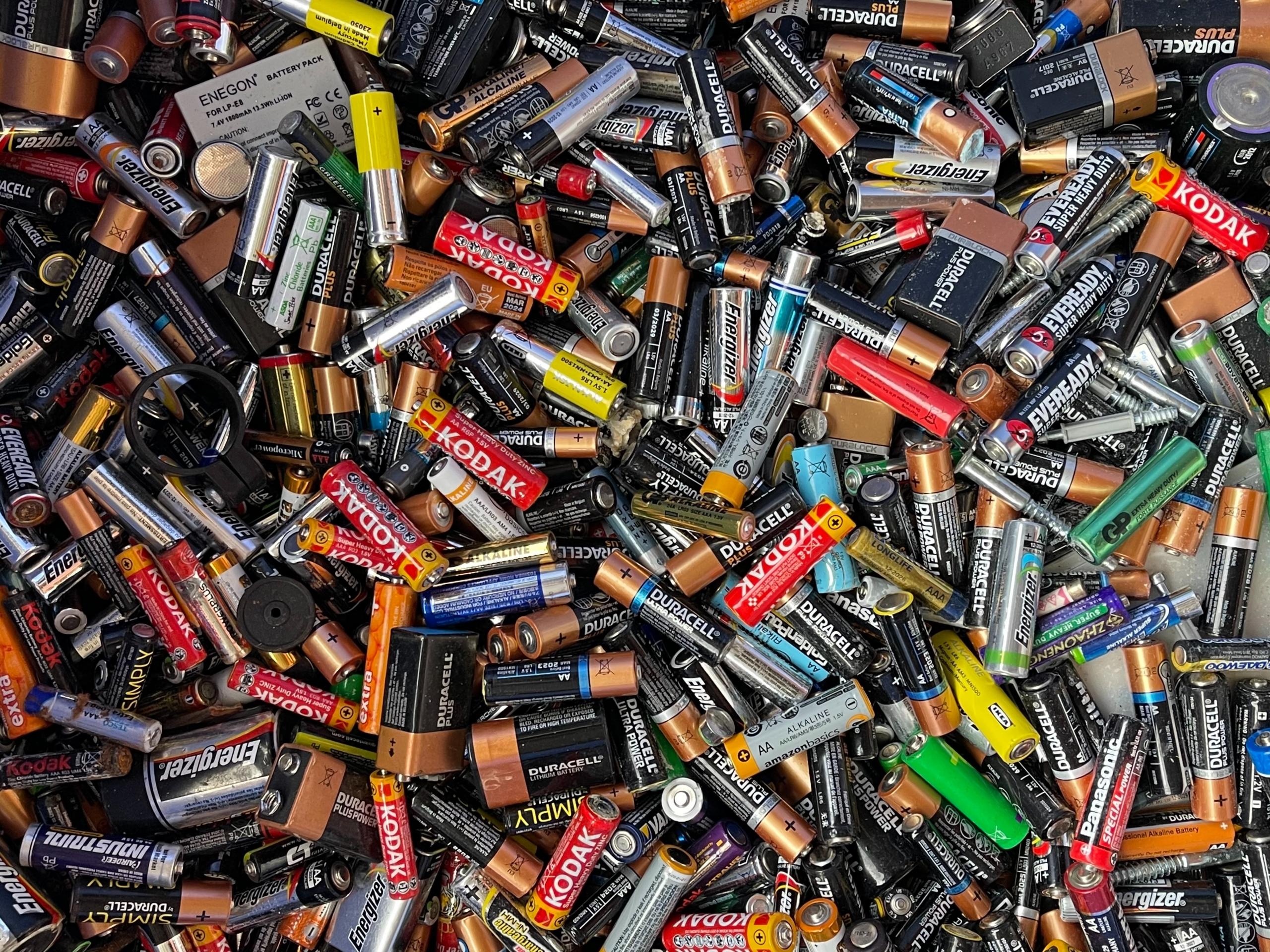 Viele Batterien in unterschiedlichen Formen und Größen liegen auf einem Haufen.