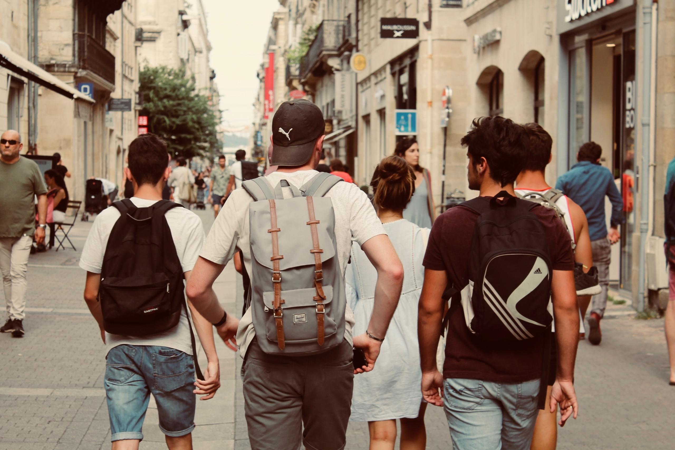 Eine Gruppe aus fünf Jugendlichen geht durch eine belebte Einkaufsstraße.