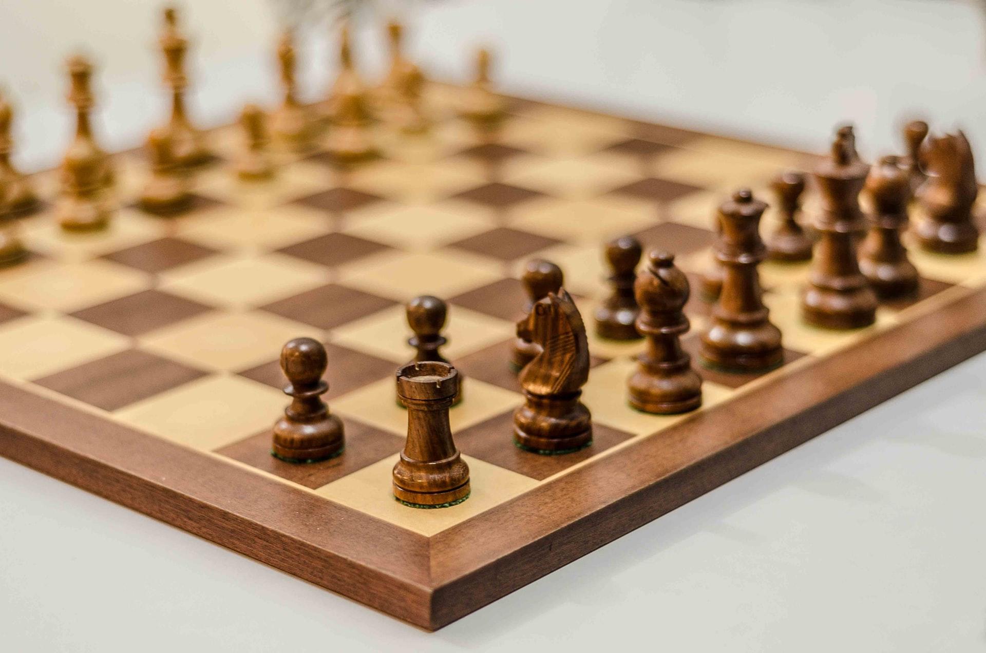 Ein hölzernes Schachbrett mit Spielfiguren in der Ausgangsposition