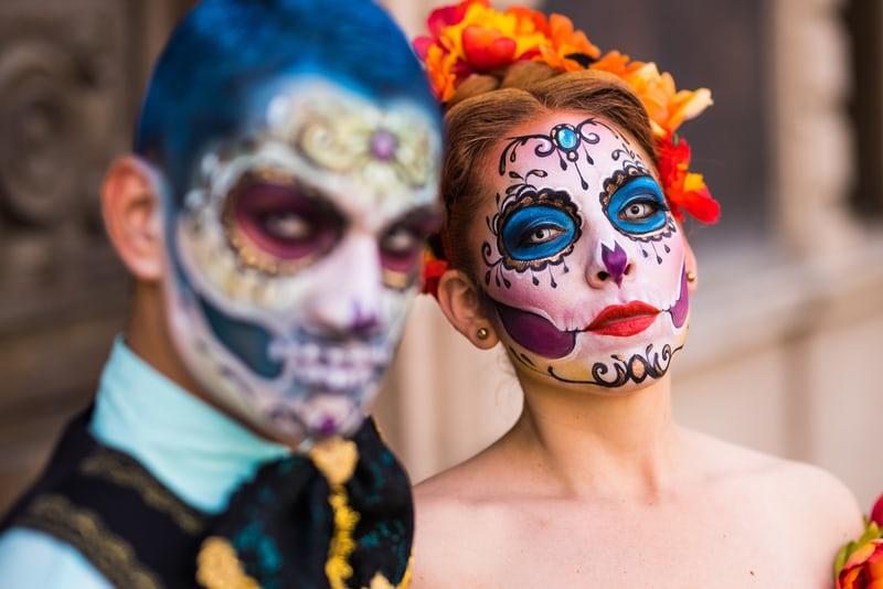 Ein Mann und eine Frau mit geschminkten Gesichtern zum dia de los muertos.