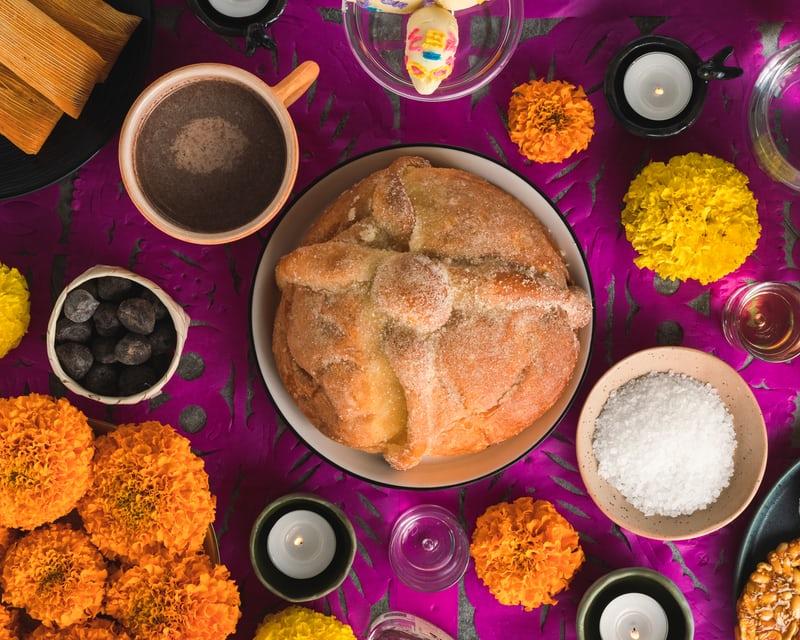 Gedeckter Tisch mit Ringelblumen und dem Brot der Toten.